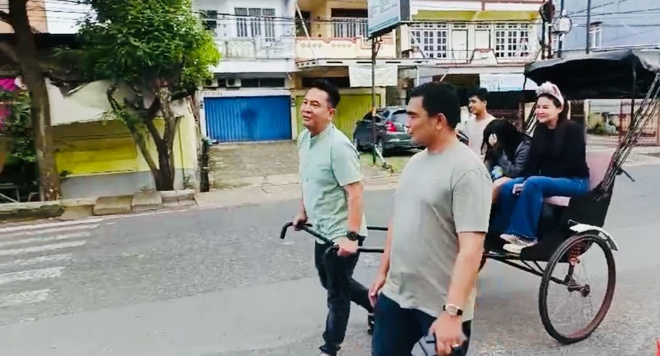 Kapolresta Jambi Kombes Pol Boy Binanga Siregar saat menarik becak rickshaw