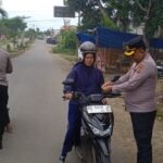 Kapolres AKBP Maulia Kuswicaksono memasangkan bendera merah putih kepada pengendara sepeda motor