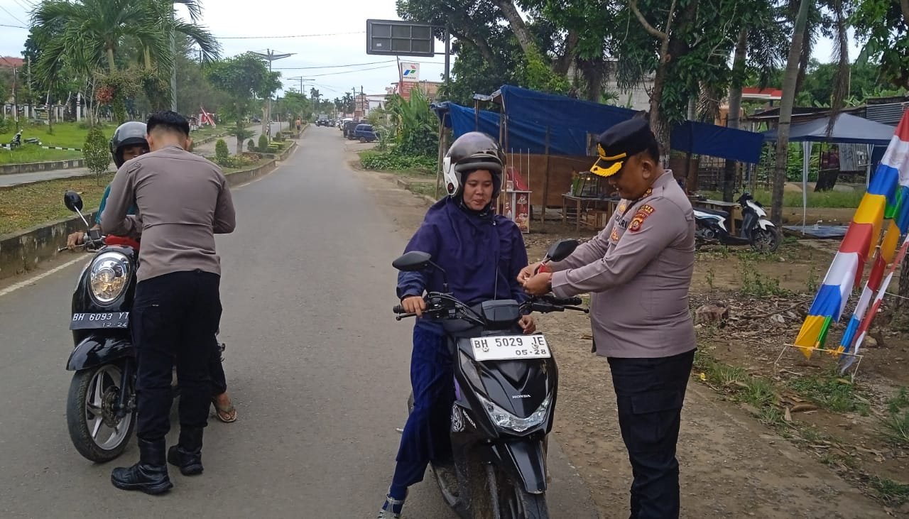 Kapolres AKBP Maulia Kuswicaksono memasangkan bendera merah putih kepada pengendara sepeda motor