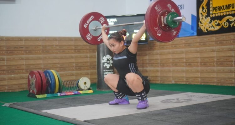 Aksi lifter andalan Pabsi Jambi Yuliana Klarisa dan membawanya lolos ke seleknas Sea Gamea di Thailand