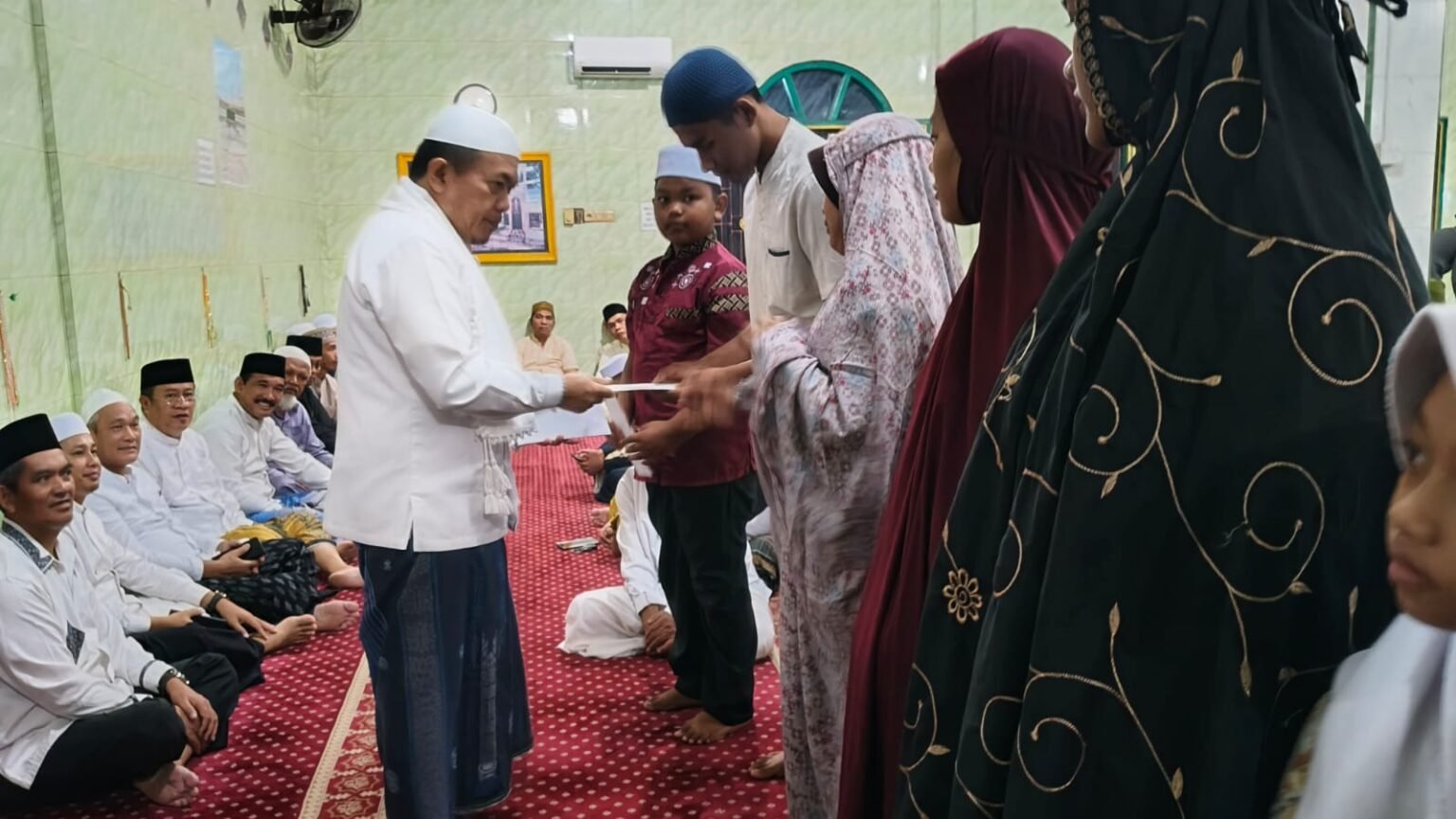 Gubernur Jambi Al Haris menyerahkan santunan kepada anak yatim dan dhuafa di Masjid Darussa’adah Pondok Meja