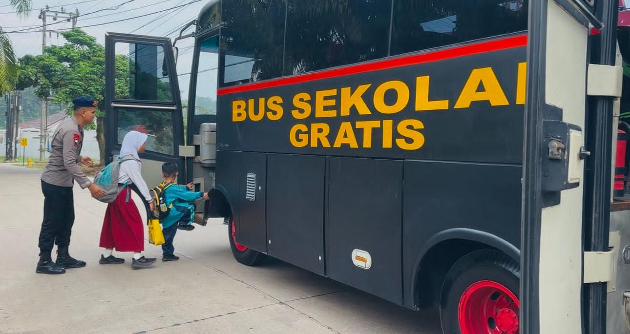 Anggota Satbrimob Polda Jambi saat menjemput salah satu pelajar untuk diantar ke sekolah menggunakan bus secara gratis