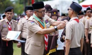 Sekda Provinsi Jambi Sudirman selaku Ka Kwarda menyematkan tanda peserta Apel Besar Hari Pramuka ke-64, di Tanjung Jabung Timur