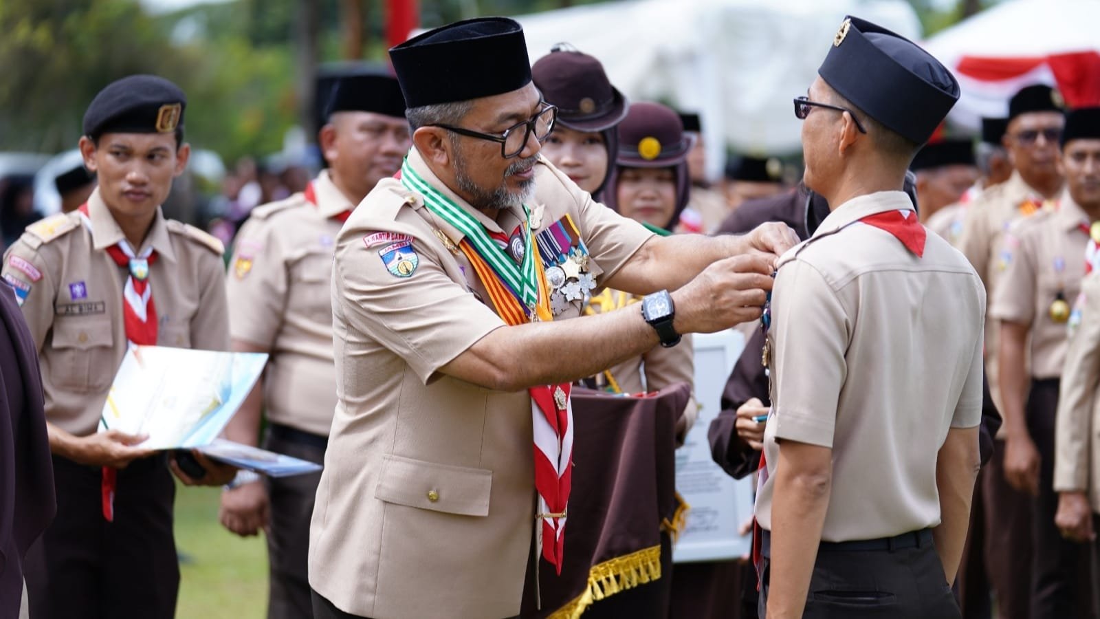 Sekda Provinsi Jambi Sudirman selaku Ka Kwarda menyematkan tanda peserta Apel Besar Hari Pramuka ke-64, di Tanjung Jabung Timur