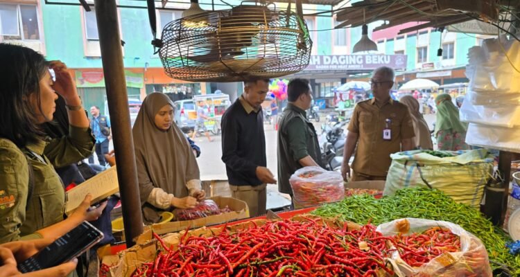 Petugas saat mengecek harga dan ketersediaan bahan pokok di Pasar Angso Duo Jambi