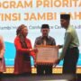 Direktur Jenderal Guru, Tenaga Kependidikan, dan Pendidikan Guru (GTKPG), Nunuk Suryani bersama Gubernur Jambi Al Haris menyerahkan piagam oenghargaan kepada peserta rapat koordinasi program prioritas GTK
