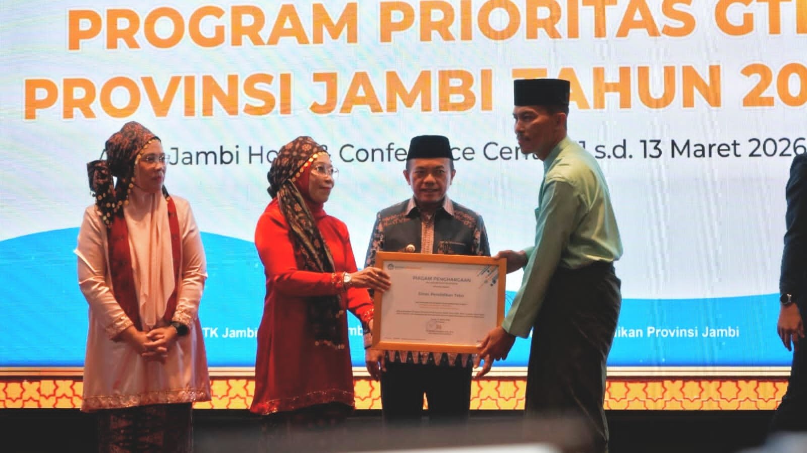 Direktur Jenderal Guru, Tenaga Kependidikan, dan Pendidikan Guru (GTKPG), Nunuk Suryani bersama Gubernur Jambi Al Haris menyerahkan piagam oenghargaan kepada peserta rapat koordinasi program prioritas GTK