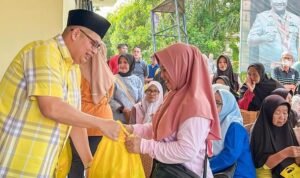 Kemas Faried menyerahkan paket sembako ke masyarakat