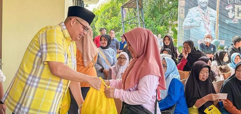 Kemas Faried menyerahkan paket sembako ke masyarakat